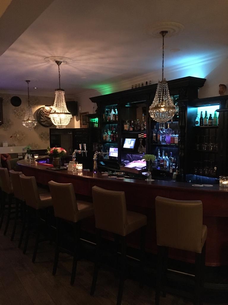 Breed uitzicht over de bar met kroonluchters